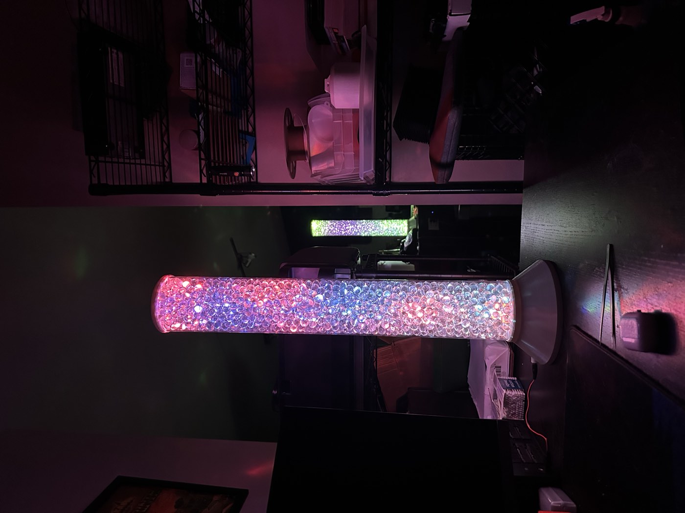 Two finished lamps lit in pink and white, one in the foreground and one further back